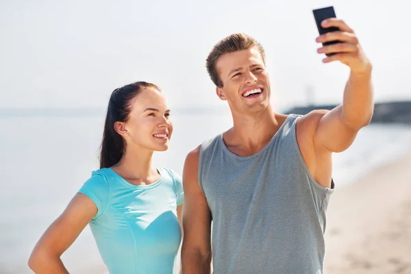 Para biorąc selfie przez smartfon na plaży — Zdjęcie stockowe