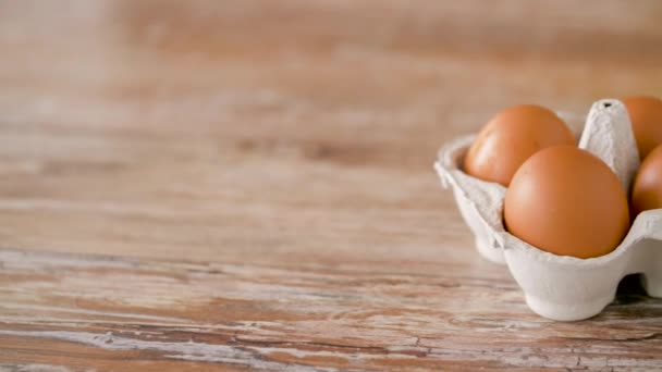 Großaufnahme von Eiern in Pappschachtel auf Holztisch — Stockvideo