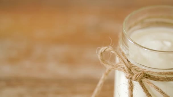 Primer plano de yogur o crema agria en frasco de vidrio — Vídeo de stock
