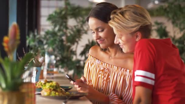 Amies avec smartphone au restaurant — Video