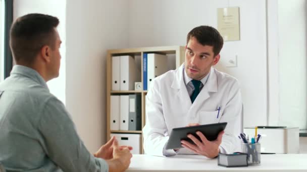 Läkare med TabletPC och manlig patient på sjukhus — Stockvideo