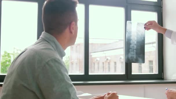 Läkare med röntgen och manlig patient på sjukhus — Stockvideo