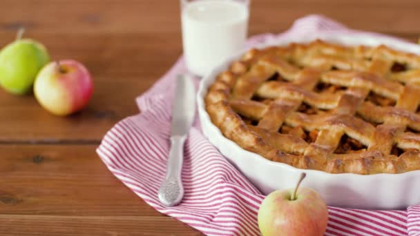 Закрыть яблочный пирог и стакан молока на столе — стоковое видео