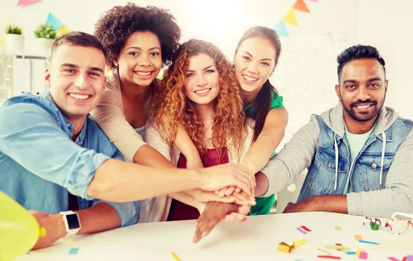 happy business team at office party holding hands