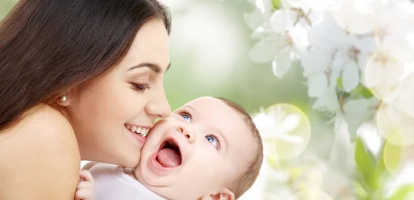 Mãe com bebê sobre fundo flor de cereja — Fotografia de Stock