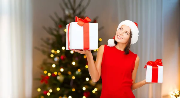 Uśmiechnięta kobieta w kapeluszu w santa Boże Narodzenie prezenty — Zdjęcie stockowe