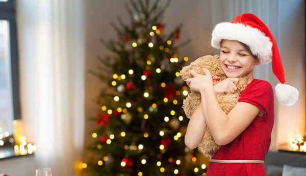 Meisje in kerstmuts met teddybeer op Kerstmis — Stockfoto