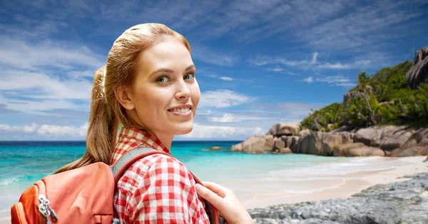 Счастливая женщина с рюкзаком над пляжем Сейшельских островов — стоковое фото