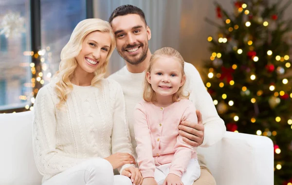 Familia feliz en casa sobre las luces del árbol de Navidad — Foto de Stock