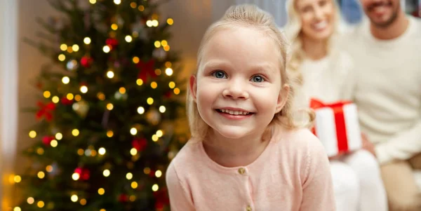Счастливая девочка с семьей над елкой — стоковое фото