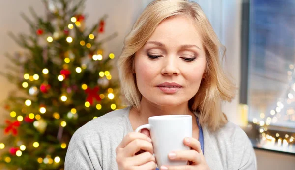 Vrouw met een kopje thee of koffie op Kerstmis — Stockfoto