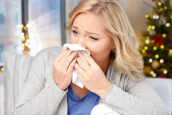 Close up of ill woman blowing nose on christmas — Stock Photo, Image