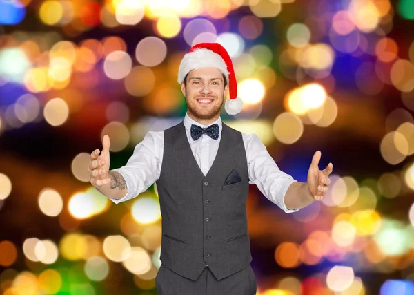 Homem feliz em santa chapéu segurando algo imaginário — Fotografia de Stock