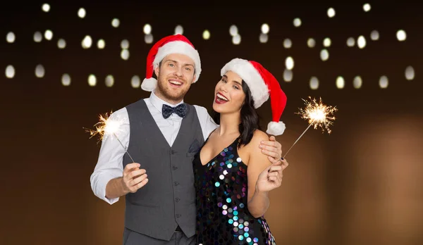 Feliz casal em santa chapéus na festa de Natal — Fotografia de Stock