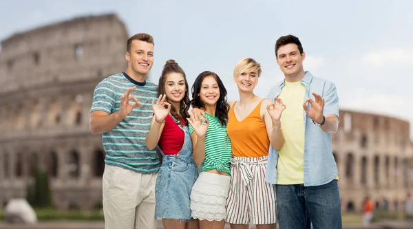 Glada vänner visar ok hand underteckna över Colosseum — Stockfoto