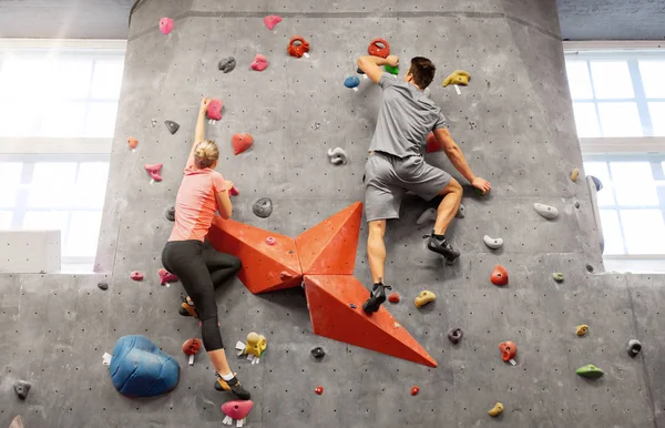 Homme et femme escaladant un mur à la salle de gym intérieure — Photo