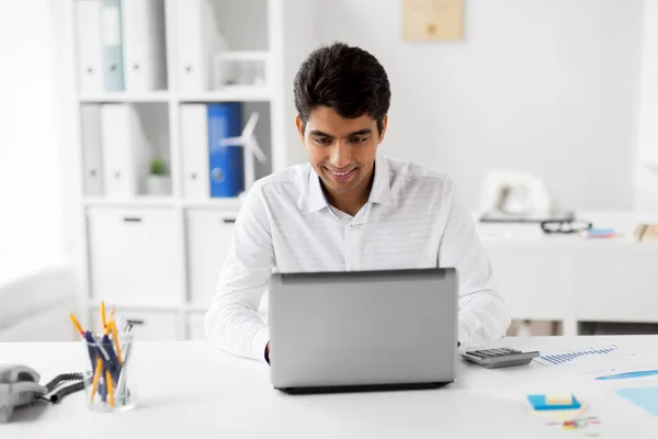 Homem de negócios com laptop e papéis no escritório — Fotografia de Stock