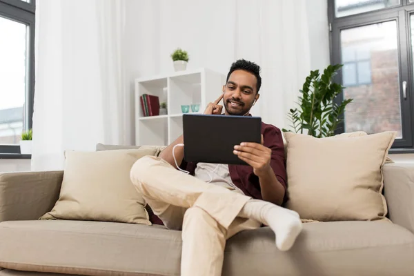 Homme dans les écouteurs avec tablette pc écouter de la musique — Photo