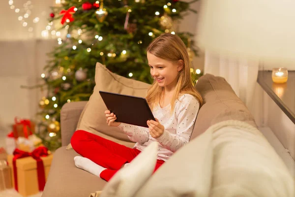 Menina sorridente com tablet pc em casa de Natal — Fotografia de Stock