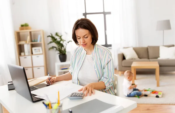 Μητέρα εργάζεται στο laptop και μωρό παιδί στο σπίτι — Φωτογραφία Αρχείου