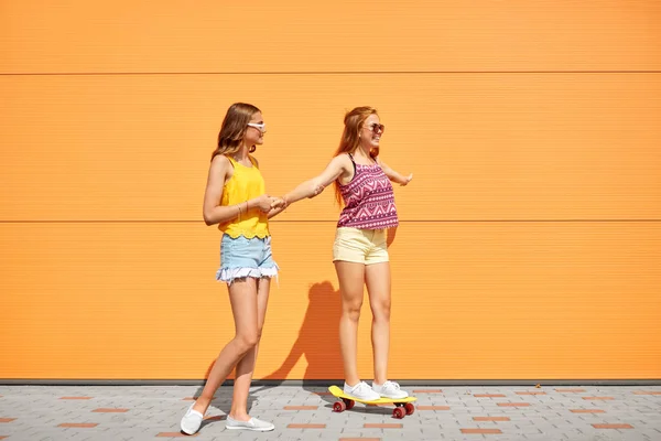 Chicas adolescentes montando monopatín en la calle de la ciudad — Foto de Stock