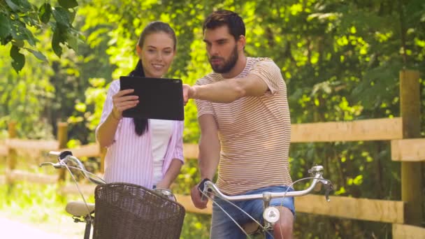 Couple with tablet pc and bicycles at summer park — Stock Video