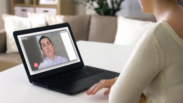 Mujer con portátil que tiene videoconferencia en casa — Vídeo de stock