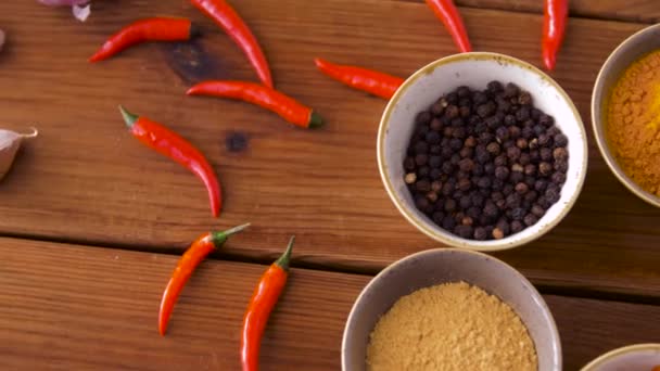 Skålar med olika kryddor på träbord — Stockvideo