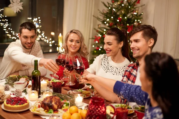 Amigos comemorando o Natal e beber vinho — Fotografia de Stock