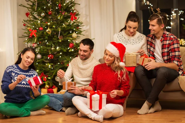 Amigos comemorando o Natal e abrindo presentes — Fotografia de Stock