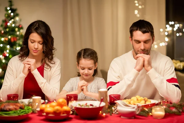 Familie bidden voor de maaltijd bij kerstdiner — Stockfoto