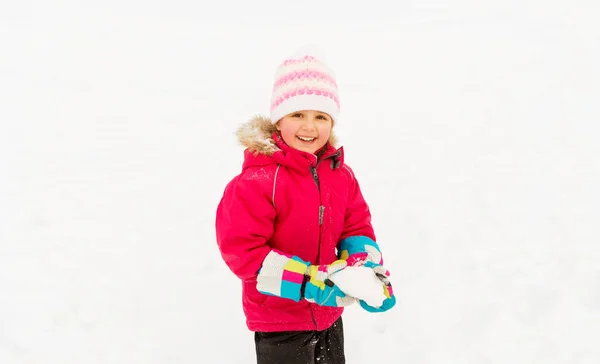 Χαρούμενο κοριτσάκι που παίζει με το χιόνι το χειμώνα — Φωτογραφία Αρχείου