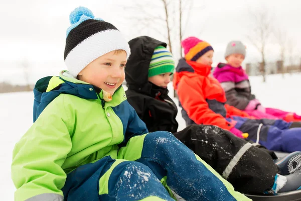 Szczęśliwe dzieciaki sanki Jazda zimą — Zdjęcie stockowe