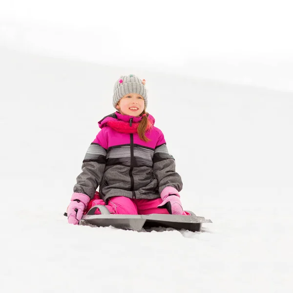 Happy little girl on sled outdoors in winter — Stock Photo, Image