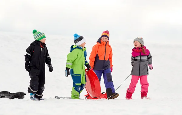 快乐的小孩子与雪橇乘雪橇玩在冬天 — 图库照片