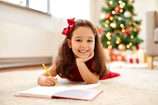 Meisje schrijven kerst verlanglijstje thuis — Stockfoto