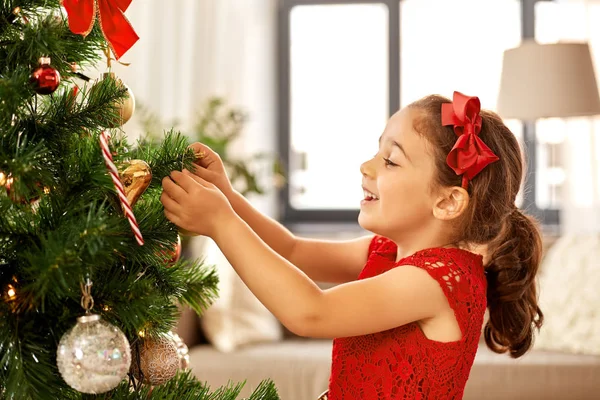 Niña decorando el árbol de Navidad en casa —  Fotos de Stock