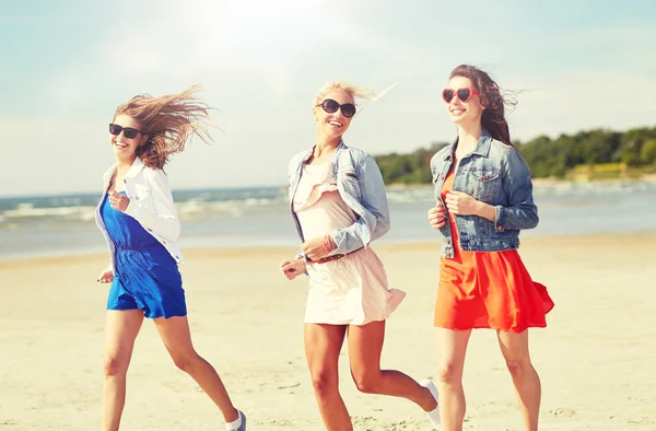 Grupo de mujeres sonrientes en gafas de sol en la playa — Foto de Stock