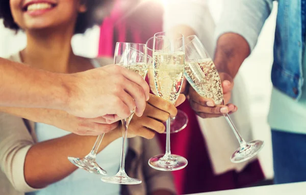 Vänner som spottar glas champagne på fest — Stockfoto