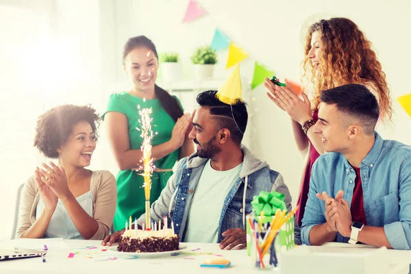 team greeting colleague at office birthday party