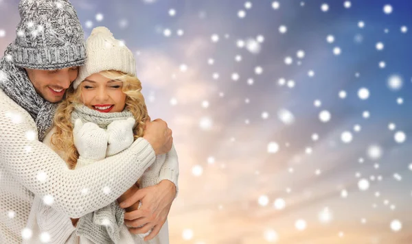 Sorrindo casal em camisolas sobre fundo de neve — Fotografia de Stock