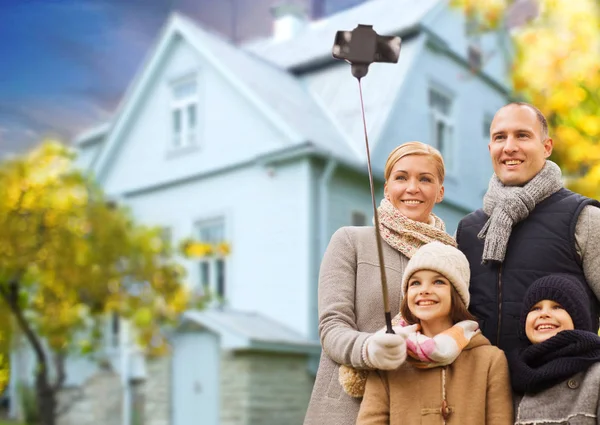 Family takes autumn selfie by cellphone over house — Stock Photo, Image