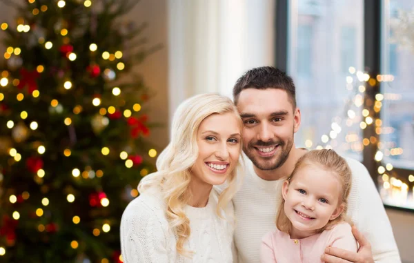 Ευτυχισμένη οικογένεια στο σπίτι πάνω από το χριστουγεννιάτικο δέντρο φώτα — Φωτογραφία Αρχείου