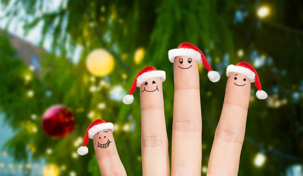 Пальцы в шляпах Санты на рождественской елке — стоковое фото