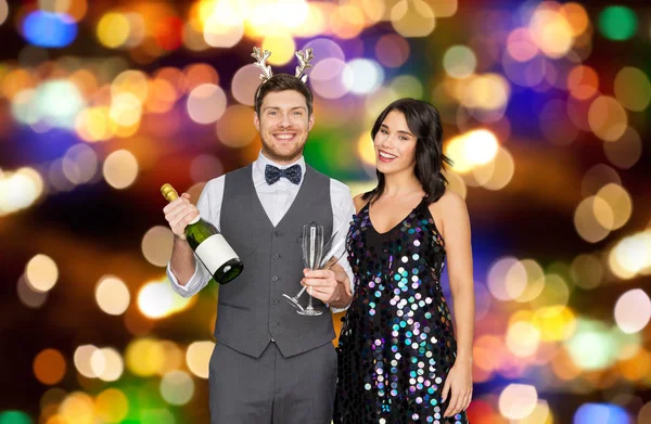 Pareja con botella de champán en la fiesta de Navidad — Foto de Stock