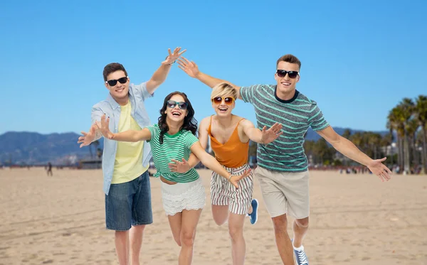 Amis en lunettes de soleil s'amuser sur la plage de venise — Photo