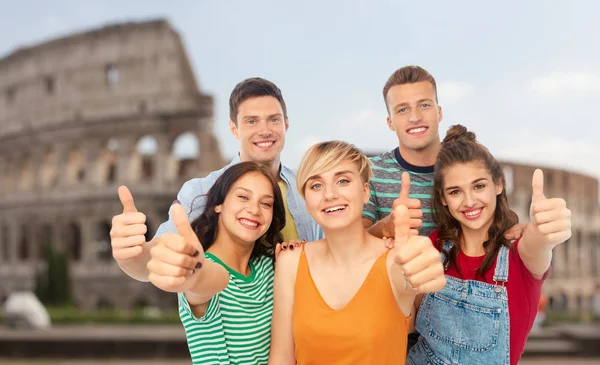 Счастливые друзья, показывающие большие пальцы над Колизеем — стоковое фото