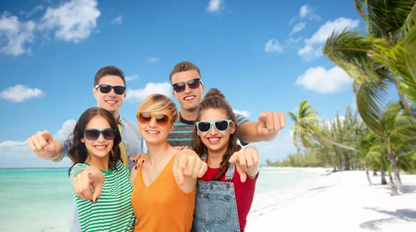 Vrienden in zonnebril wijzend op u over strand — Stockfoto