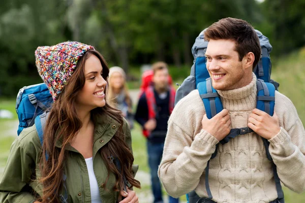 Amigos felices o viajeros con mochilas de senderismo —  Fotos de Stock