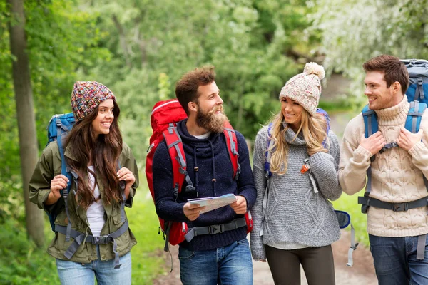 Friends or travelers hiking with backpacks and map — Stock Photo, Image